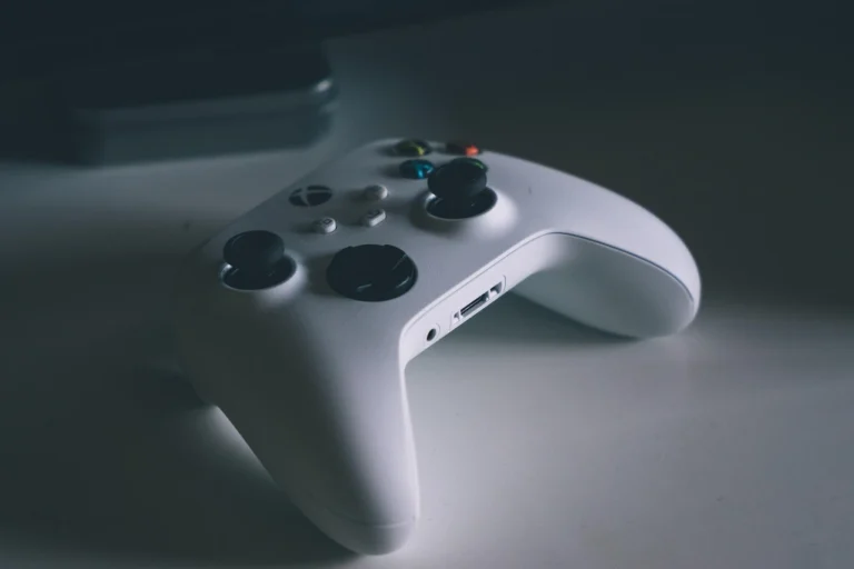 Manette Xbox blanche posée sur une table dans la pénombre
